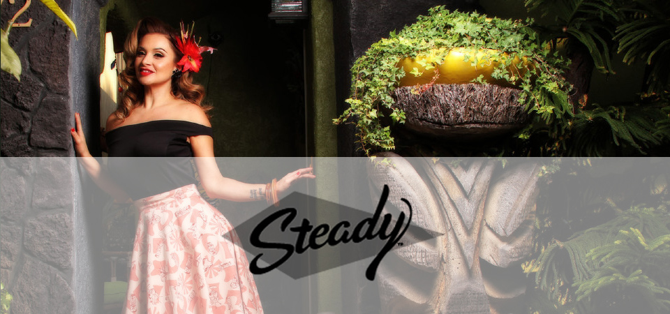 Steady Clothing Eine Frau trägt ein 50er Jahre Outfit im Tiki-Style, Logo der Marke Steady Clothing