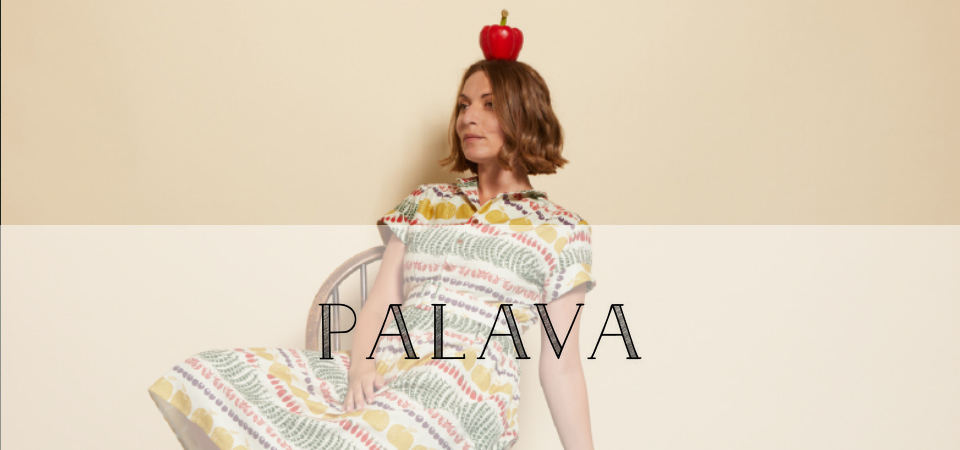 Palava Eine Frau in einem Kleid mit Gemüse-Muster balanciert einen Apfel auf dem Kopf, Logo der Marke Palava