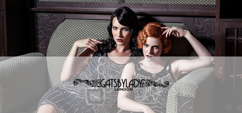 Gatsbylady Zwei Frauen in 20er Jahre Kleidern auf einem Sofa, Logo der Marke Gatsbylady