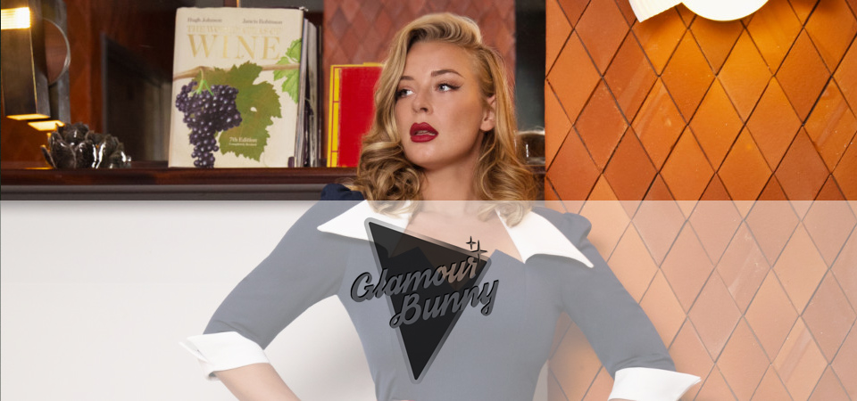 Glamour Bunny Eine Frau in einem blauen 50er Jahre Kleid mit weißem Kragen, Logo der Marke Glamour Bunny