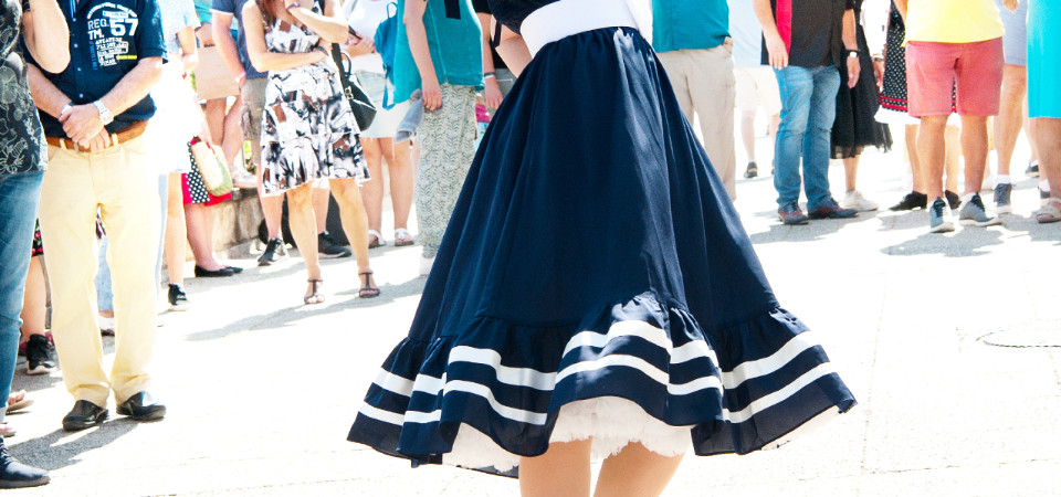 Swing- und Petticoat-Kleider Ein Model auf einer Modenschau trägt ein Matrosenkleid im 50er Jahre Stil mit Petticoat