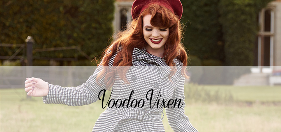 Voodoo Vixen Eine Frau in einem Tweedmantel steht auf einer Wiese, Logo der Marke Voodoo Vixen